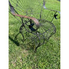 an old metal chair sitting in the grass