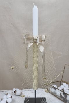 The Bright Candle Discover our baptism or wedding candle, wrapped in a golden ribbon, beautifully draped in delicate tulle. Its bow and golden leaves add a touch of sophistication. With a size of 40 cm, it is the perfect element to enhance your event. Our candle embodies elegance and charm, capturing all eyes with its sparkling gold ribbon that delicately wraps around its silhouette. The draped tulle gives it an aura of grace and lightness. The knot and the golden leaves bring a refined touch, c Wedding Communion Candle, Candle Ceremony, Candle Wedding Gift, Golden Ribbon, Ceremony Candles, Candle Wedding, Baptism Candle, Wedding Candle, Baptism Girl