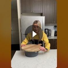 a woman standing in front of a pot on top of a counter