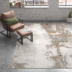 a chair and ottoman in an empty room with brick walls, windows, and a rug on the floor