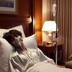 a woman laying in bed with an oxygen mask on