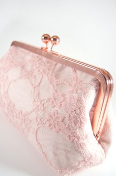 a pink lace clutch bag with two gold metal clasps