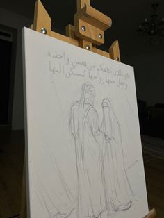 an easel with a drawing of two people standing next to each other