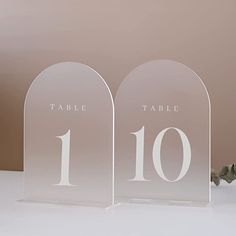 two clear acrylic table numbers are on display