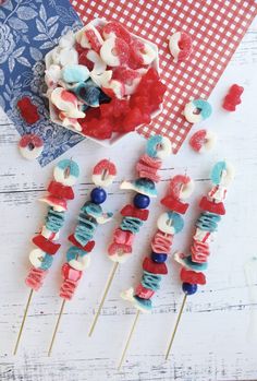 red, white and blue lollipops on a stick with candy in them