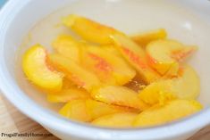 a bowl filled with sliced fruit on top of a wooden table