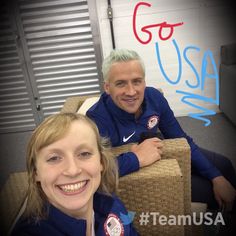 two people sitting on a couch in front of a sign that says go usa with the caption team usa