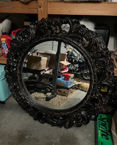 a mirror sitting on top of a wooden table next to a shelf filled with boxes