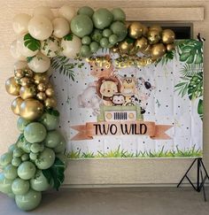 a jungle themed birthday party with balloons and streamers on the wall, along with an animal banner