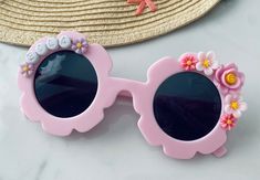 Brand new to MeaganElizabethCo, custom pastel flower sunnies! We are so excited to be adding other fashion accessories to our shop for your littles! And who could pass up these adorable pink flower sunnies?!? These sunnies are the perfect accessory for any vacation, photoshoot, birthday party or everyday where! These sunnies can be customized by YOU for your little fashionista! Step 1: Pick your sunnies and font color   Step 2: Use PERSONALIZE BOX at check out to note NAME, WORD(S) A STANDARD SUNNIES ORDER WILL COME WITH YOUR PERSONALIZED WORD/NAME/SAYING AND FLOWER EMBELLISHMENTS VARYING IN SIZE AND COLOR BASED ON FONT SELECTION AND LENGTH OF PERSONALIZATION  PRODUCT DETAILS:  SUNGLASSES ARE SIZED FOR TODDLERS/YOUNG KIDS UP TO AGE 10 *All letters are capitalized  Lightweight but sturdy. A Customizable Pink Sunglasses For The Beach, Personalized Pink Sunglasses For Beach, Spring Gift Sunglasses With Uv Protection, Spring Gift Sunglasses With Adjustable Fit, Spring Gift Adjustable Sunglasses, Spring Gift Sunglasses With Gradient Lenses, Spring Gift Sunglasses With Tinted Lenses, Cute Pink Sunglasses For Spring, Spring Tinted Sunglasses As Gift