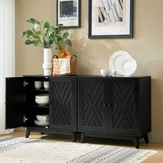 a black cabinet sitting in the corner of a room with pictures on the wall above it