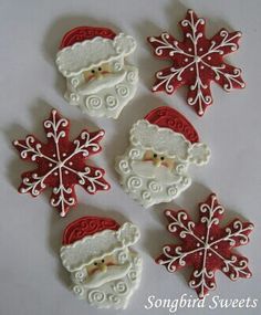 christmas cookies decorated like santa claus and snowflakes on a white table with the words songbird sweets written below