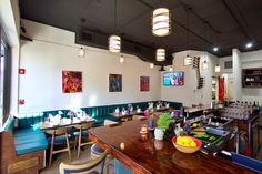 a restaurant with tables, chairs and pictures on the wall above it's counter