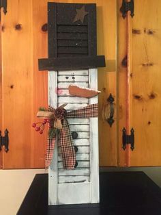 a snowman made out of an old door with a bow on it's head