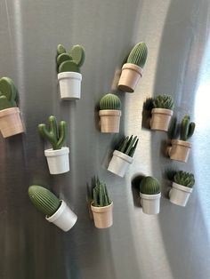 small cactus plants are placed on the side of a refrigerator