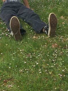 a person sitting in the grass with their feet up