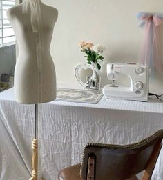 a sewing machine sitting on top of a table next to a dressmaker's mannequin