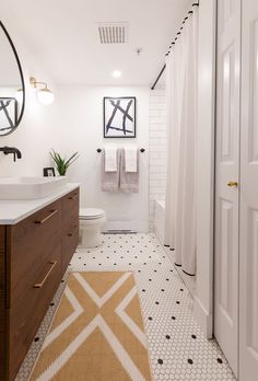 a white bathroom with black and gold accents