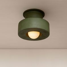 a green light fixture hanging from the ceiling