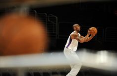 a man holding a basketball in his right hand and wearing white on the other side