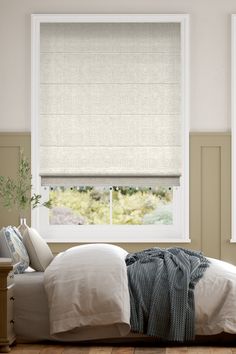 two windows with roman shades in a bedroom