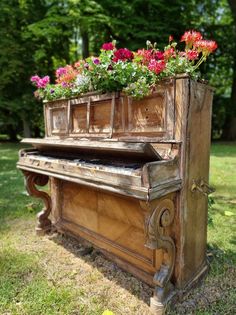 an old piano with flowers growing out of it