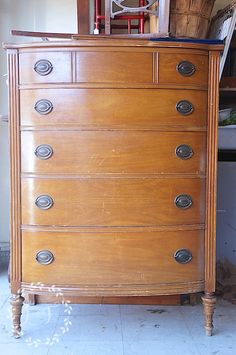 an old wooden dresser with many drawers and knobs on it's sides in a room