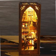 an open book case sitting on top of a wooden floor next to a black wall