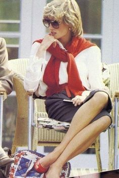 a woman sitting on top of a chair with her legs crossed