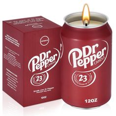 a candle that is next to a red box with the word dr pepper on it