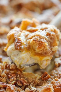 a spoonful of dessert is being held over the top of a casserole