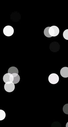 blurry circles on black background with white dots in the middle and one circle at the bottom