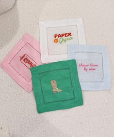 four embroidered napkins with different designs on them