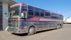 a large bus parked in front of a building next to a loading dock and garage