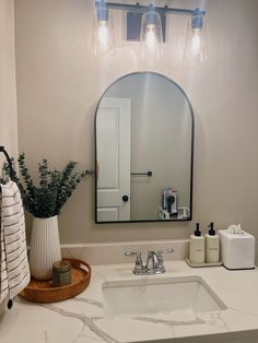 a bathroom with a sink, mirror and soap dispenser on the counter