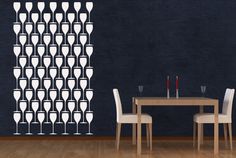 a dining room with a table and chairs in front of a wall that has wine glasses on it