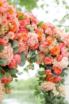 an arch covered in pink and orange flowers