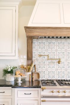 a kitchen with white cabinets and black counter tops is pictured in this image, there are two ovens next to each other