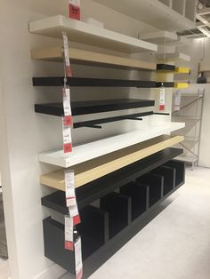 shelves with labels on them are lined up against the wall in an empty room,