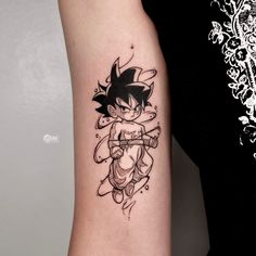 a woman's arm with a black and white tattoo of a cartoon character on it