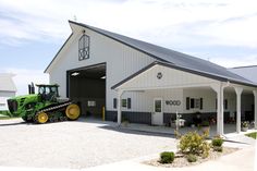 a tractor parked in front of a large white barn