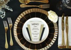 a black and gold table setting with silverware