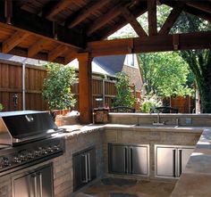 an outdoor kitchen with grill and seating area