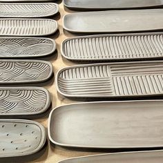 many gray plates are lined up on the counter top, and one has a fork in it