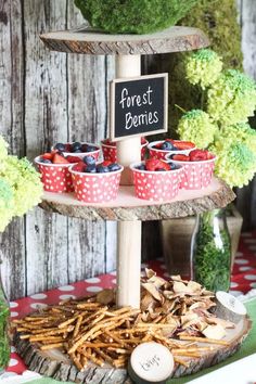 a dessert table with strawberries and cupcakes on it, along with a sign that says forest berries