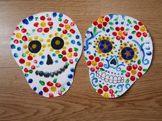 two paper plates decorated to look like skulls with different colored dots on their faces and eyes