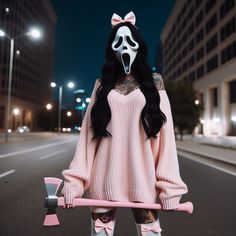 a woman in pink sweater holding a skateboard with white face paint and black hair