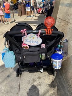 a baby stroller with items on the side of it