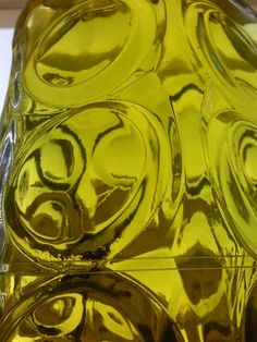 a yellow glass vase sitting on top of a table