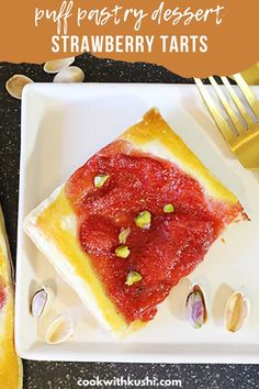 a piece of strawberry dessert on a plate with a fork and spoon next to it